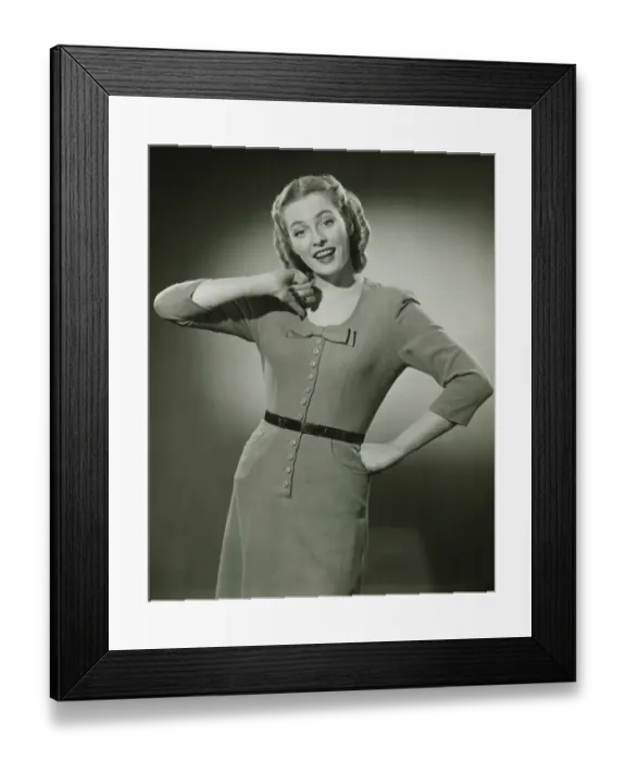 Framed Print : Young woman pointing at herself, posing in studio, (B&W), portrait Framed Print : Young woman pointing at herself, posing in studio, (B&W), portrait