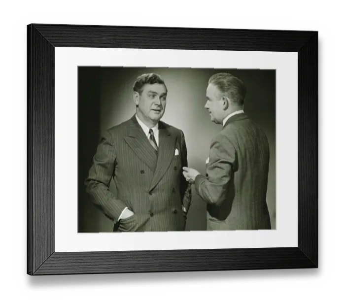 Framed Print : Two businessmen talking in studio, (B&W), portrait Framed Print : Two businessmen talking in studio, (B&W), portrait