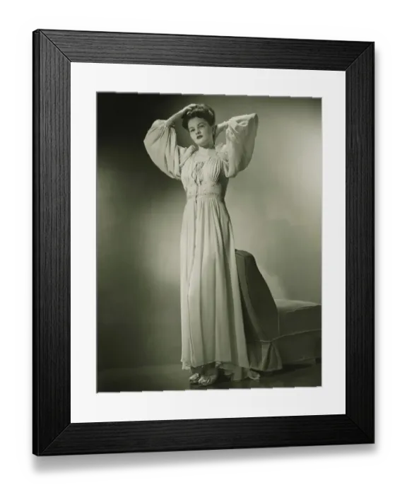 Framed Print : Woman in nightdress standing by chair in studio, (B&W) Framed Print : Woman in nightdress standing by chair in studio, (B&W)