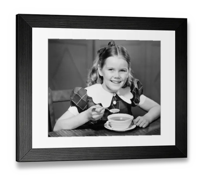 Framed Print : Girl (10-11) eating soup at table (B&W), portrait Framed Print : Girl (10-11) eating soup at table (B&W), portrait