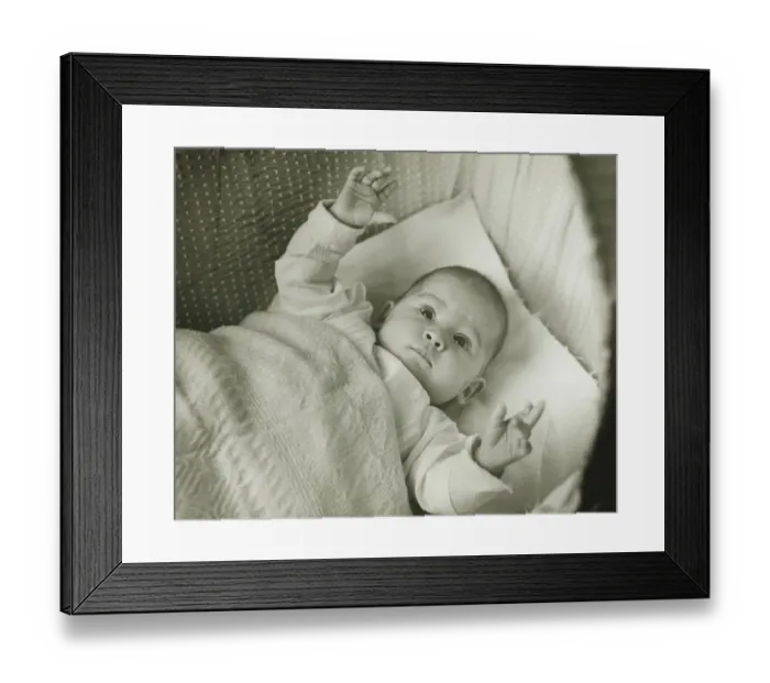 Framed Print : Baby girl (6-12 months) lying in bed with arms raised, (B&W) Framed Print : Baby girl (6-12 months) lying in bed with arms raised, (B&W)