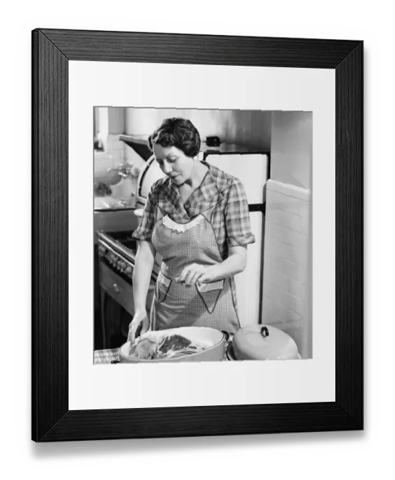Framed Print : Woman seasoning meat in roasting dish (B&W) Framed Print : Woman seasoning meat in roasting dish (B&W)