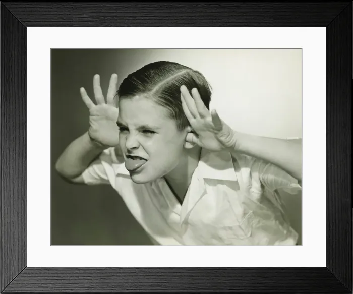 Framed Print : Boy (8-9) making face in studio, (B&W) Framed Print : Boy (8-9) making face in studio, (B&W)