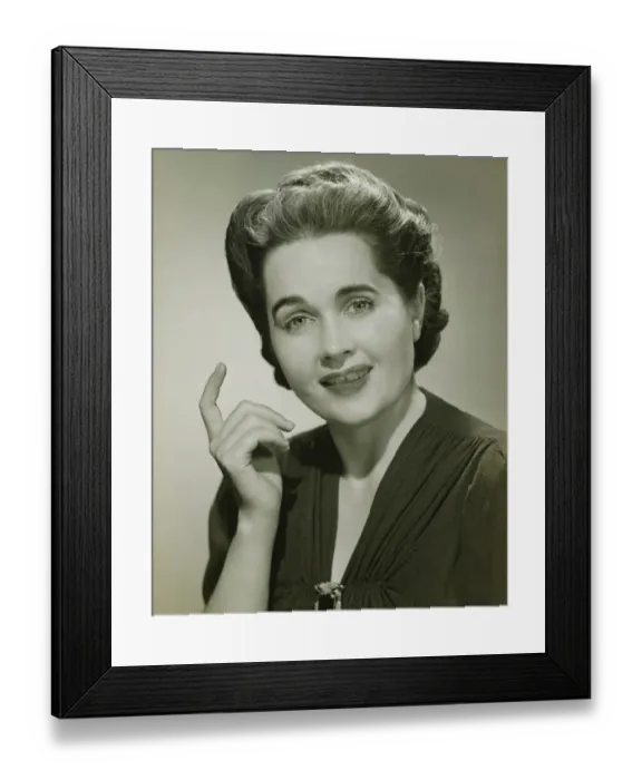 Framed Print : Young woman with raised index finger in studio, (B&W), portrait Framed Print : Young woman with raised index finger in studio, (B&W), portrait