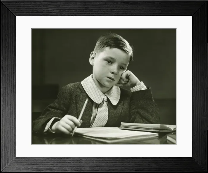 Framed Print : Boy (8-9) doing homework, (B&W), portrait Framed Print : Boy (8-9) doing homework, (B&W), portrait