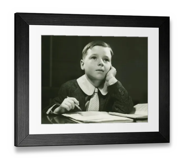 Framed Print : Boy (6-7) doing homework, (B&W), portrait Framed Print : Boy (6-7) doing homework, (B&W), portrait
