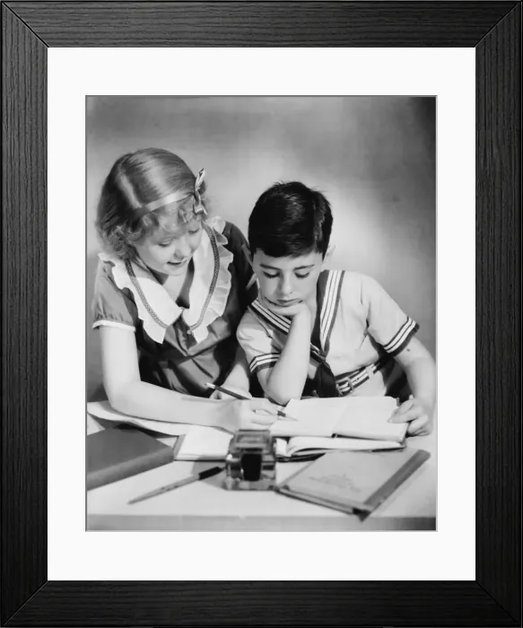 Framed Print : Sister (12-13) helping brother (8-9) with homework, (B&W)