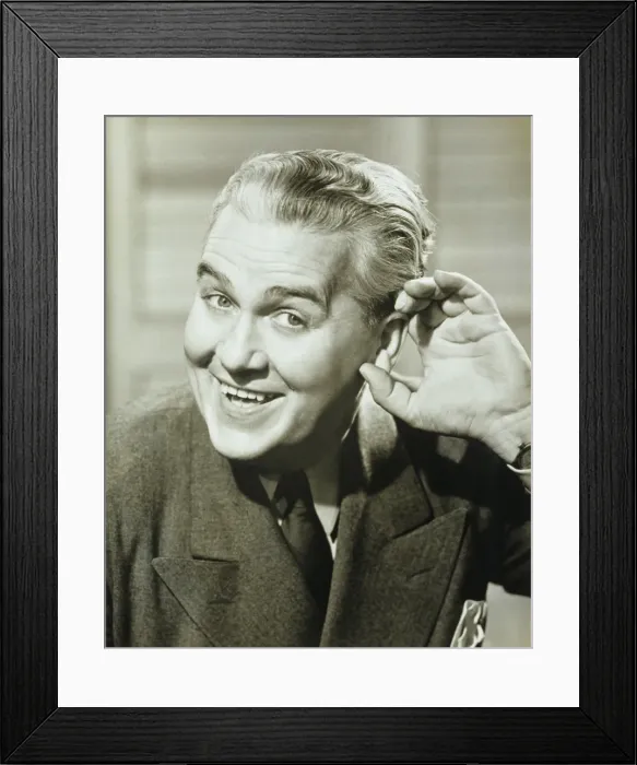 Framed Print : Man cupping hand to ear, posing, smiling, (B&W), portrait
