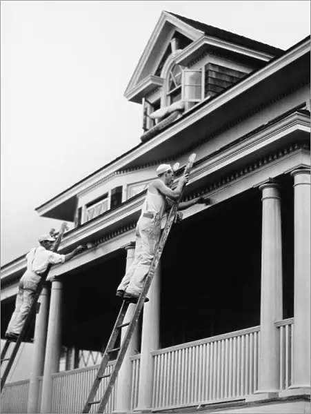 Two manual workers on ladders painting house exterior, (B&W)