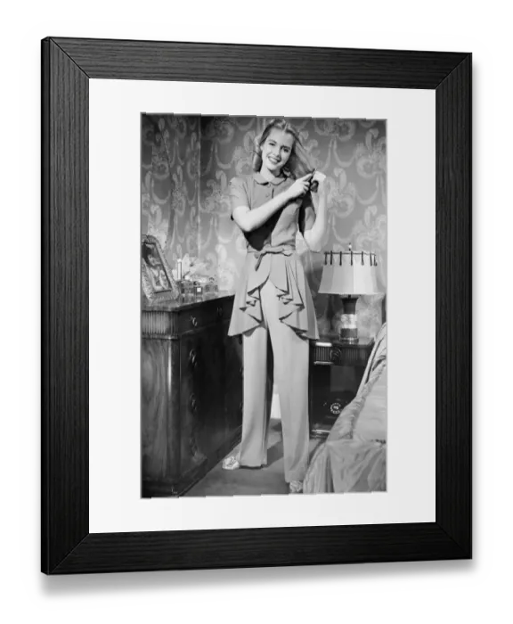 Framed Print : Woman brushing hair in bedroom, (B&W), portrait Framed Print : Woman brushing hair in bedroom, (B&W), portrait