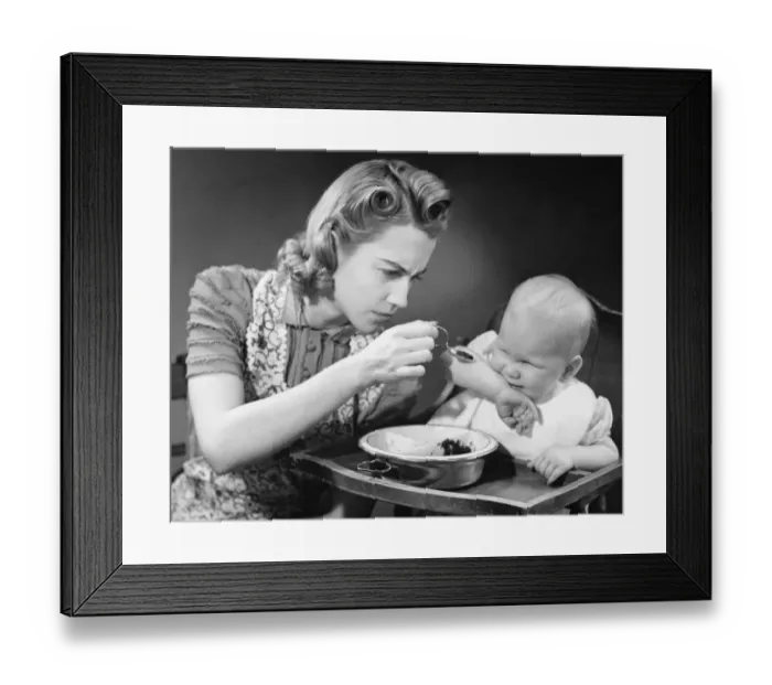 Framed Print : Mother trying to feed unwilling baby (9-12 months), (B&W) Framed Print : Mother trying to feed unwilling baby (9-12 months), (B&W)