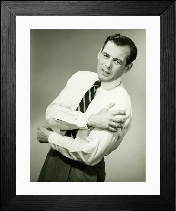 Framed Print : Businessman with aching arm in studio, (B&W) Framed Print : Businessman with aching arm in studio, (B&W)