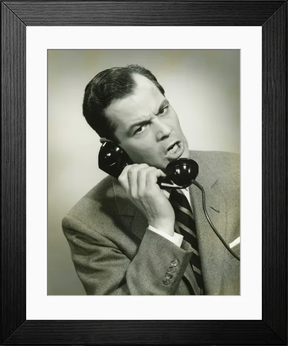 Framed Print : Businessman using phone in studio, (B&W), close-up