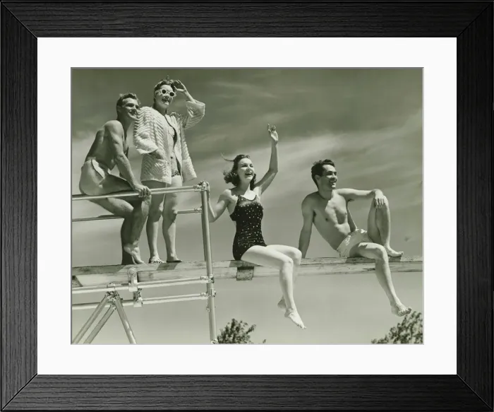 Framed Print : Two couples on springboard, (B&W), low angle view Framed Print : Two couples on springboard, (B&W), low angle view