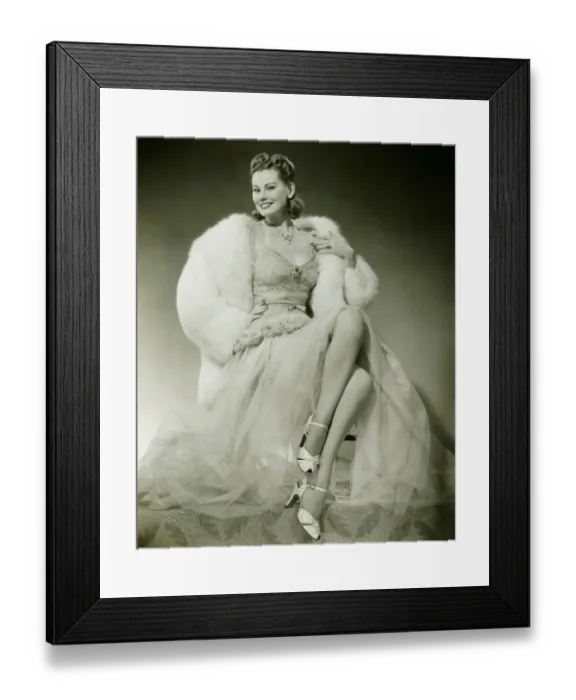 Framed Print : Glamorous woman in evening dress showing legs, posing in studio, (B&W), portrait Framed Print : Glamorous woman in evening dress showing legs, posing in studio, (B&W), portrait