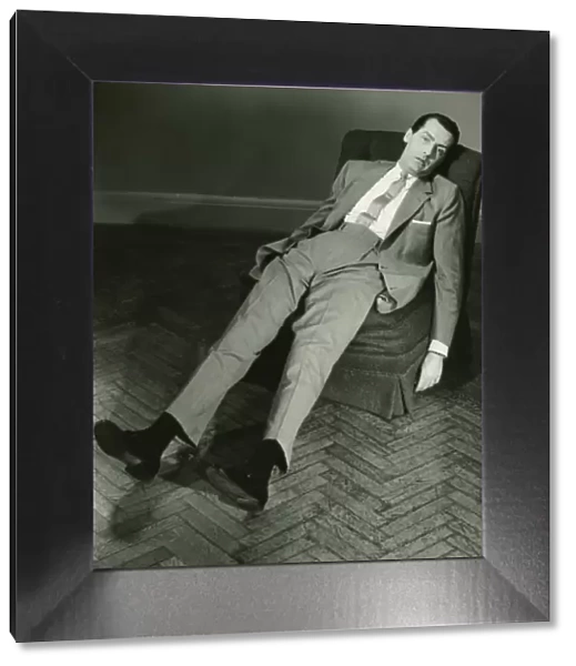 Exhausted man reclining on chair, (B&W), elevated view