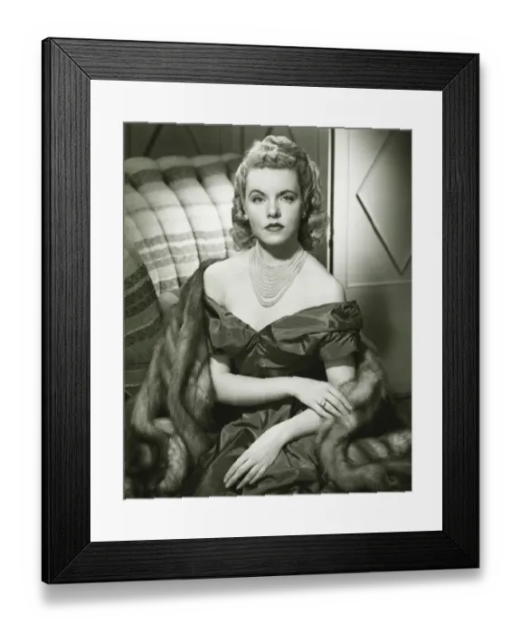 Framed Print : Young woman in evening dress sitting indoors, (B&W), portrait Framed Print : Young woman in evening dress sitting indoors, (B&W), portrait