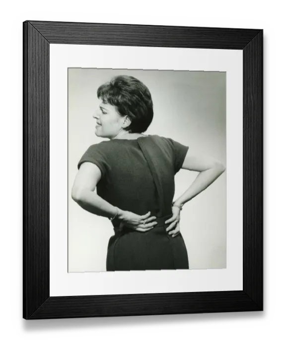Framed Print : Woman in studio grasping back in pain, (B&W) Framed Print : Woman in studio grasping back in pain, (B&W)