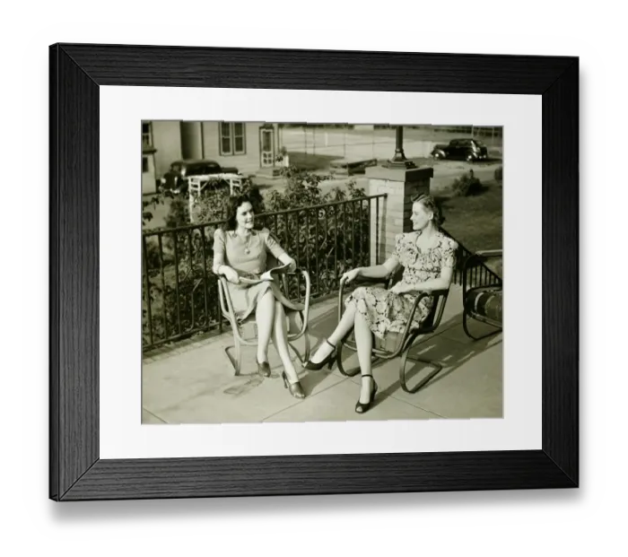 Framed Print : Two young women sitting on terrace, talking, (B&W) Framed Print : Two young women sitting on terrace, talking, (B&W)