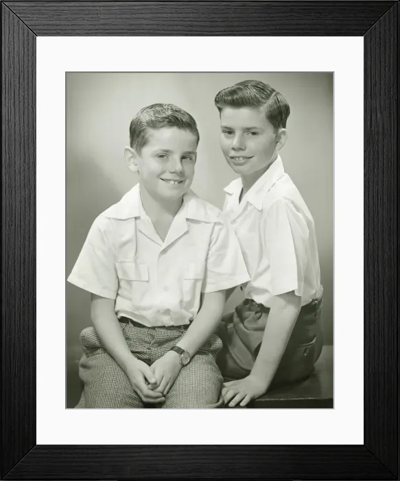 Framed Print : Brothers (8-9) (10-11) sitting in studio, smiling, (B&W), portrait Framed Print : Brothers (8-9) (10-11) sitting in studio, smiling, (B&W), portrait