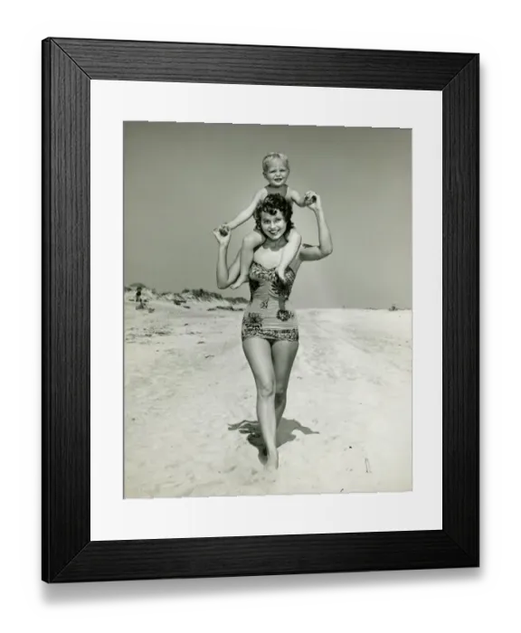 Framed Print : Mother carrying son (2-3) on shoulders, walking on beach, (B&W), portrait Framed Print : Mother carrying son (2-3) on shoulders, walking on beach, (B&W), portrait
