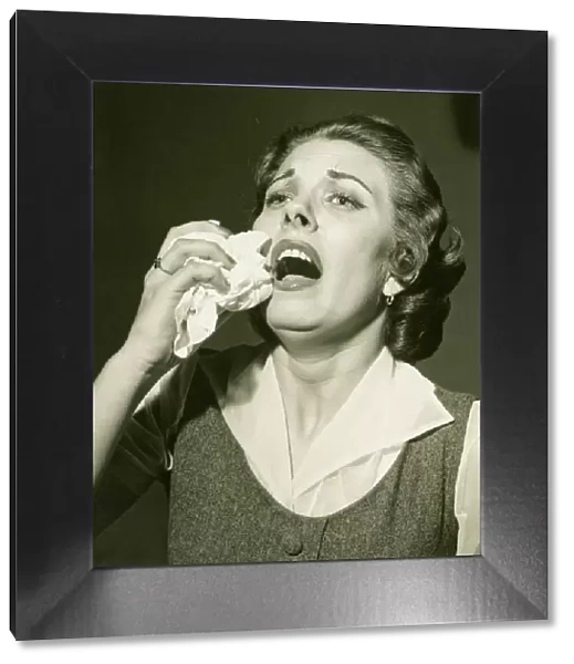 Woman holding handkerchief about to sneeze, (B&W), close-up