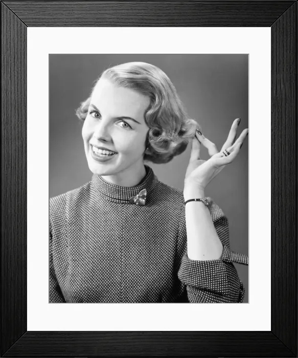 Framed Print : Smiling woman touching hair posing in studio, (B&W), portrait, close-up Framed Print : Smiling woman touching hair posing in studio, (B&W), portrait, close-up