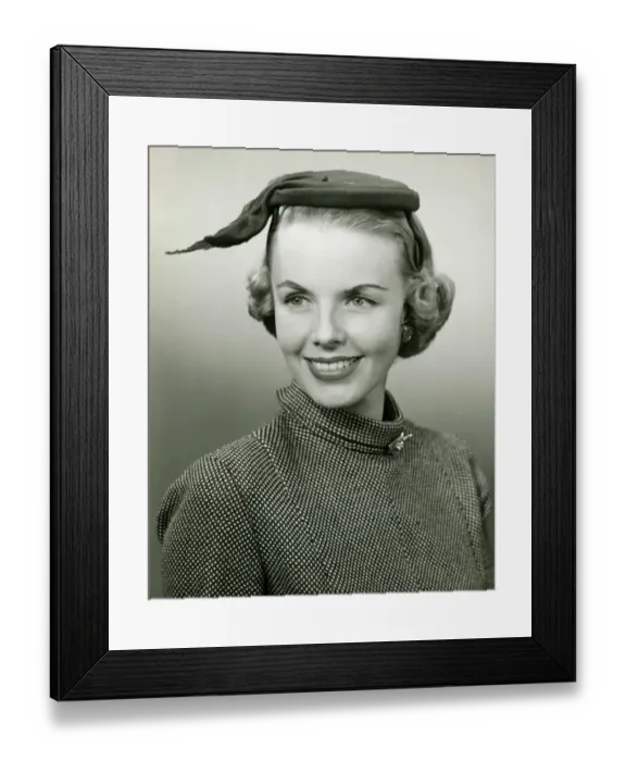 Framed Print : Smiling woman in small hat posing in studio, (B&W), portrait, close-up Framed Print : Smiling woman in small hat posing in studio, (B&W), portrait, close-up