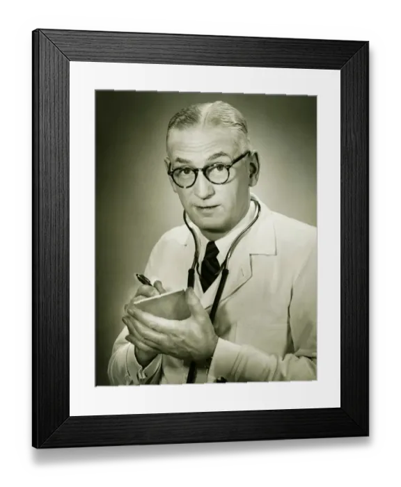 Framed Print : Doctor holding note pad posing in studio, (B&W), portrait Framed Print : Doctor holding note pad posing in studio, (B&W), portrait