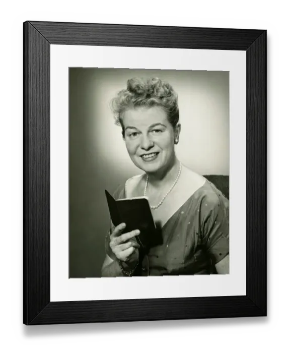Framed Print : Mature woman holding small book, posing in studio, (B&W), portrait Framed Print : Mature woman holding small book, posing in studio, (B&W), portrait