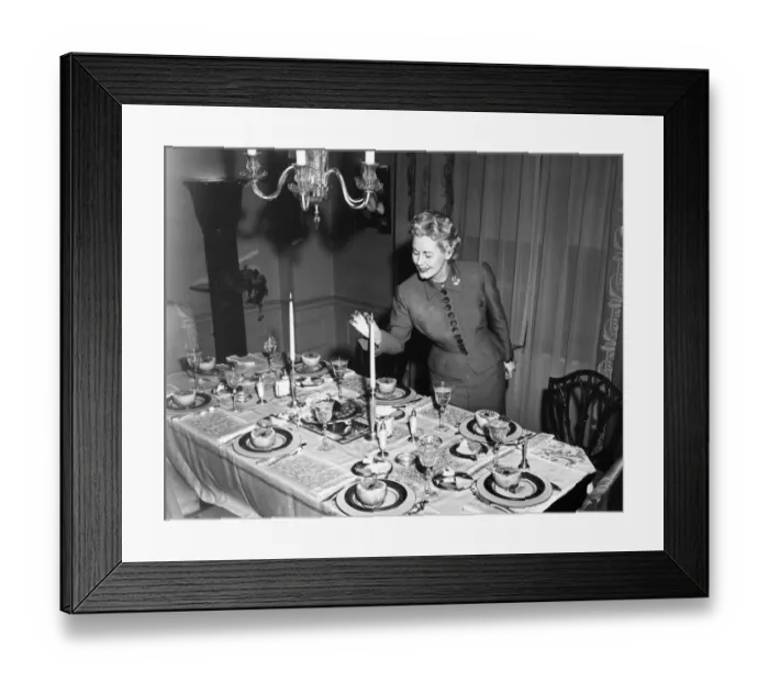 Framed Print : Woman lighting up candle, table ready for dessert, (B&W) Framed Print : Woman lighting up candle, table ready for dessert, (B&W)