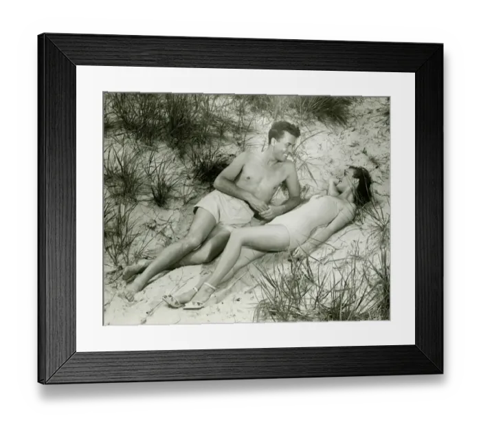Framed Print : Young couple lying on sand, (B&W), elevated view Framed Print : Young couple lying on sand, (B&W), elevated view