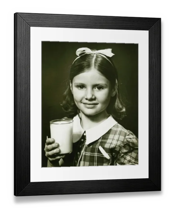 Framed Print : Girl (6-7) holding glass of milk, posing in studio, (B&W), close-up, portrait Framed Print : Girl (6-7) holding glass of milk, posing in studio, (B&W), close-up, portrait