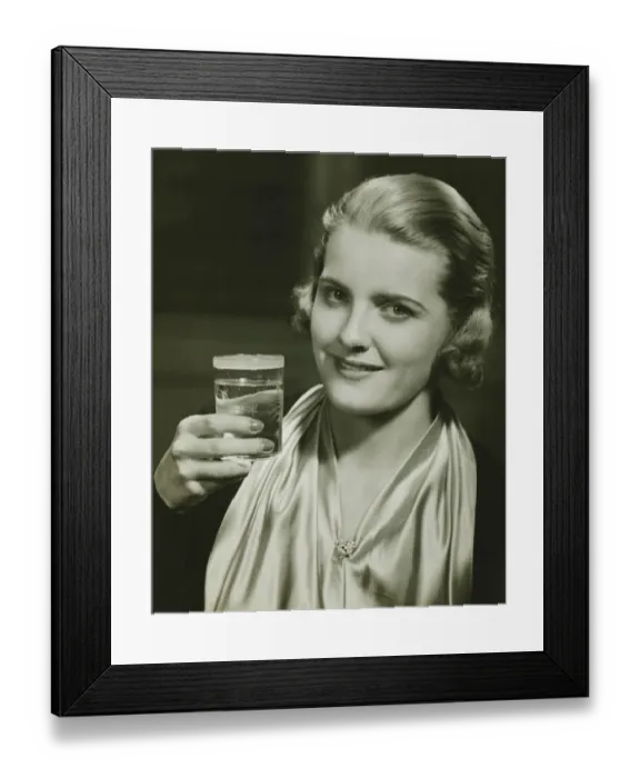 Framed Print : Elegant woman raising glass of water, posing in studio, (B&W), close-up, portrait Framed Print : Elegant woman raising glass of water, posing in studio, (B&W), close-up, portrait