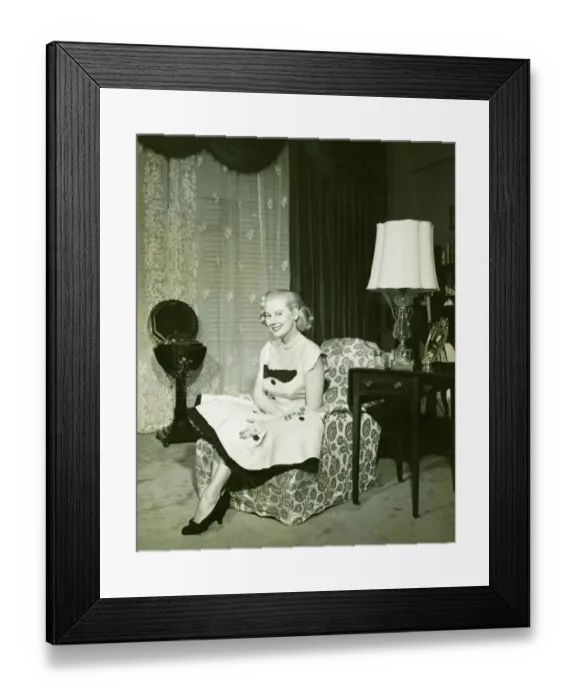 Framed Print : Woman in fashionable dress sitting on armchair in living room, (B&W), portrait Framed Print : Woman in fashionable dress sitting on armchair in living room, (B&W), portrait