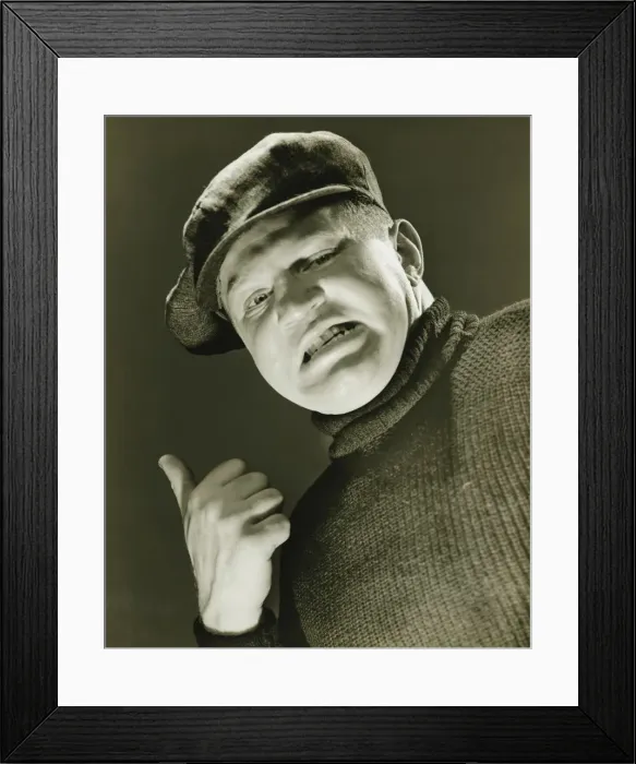 Framed Print : Tough guy showing thumb up, (B&W), close-up, portrait, low angle view Framed Print : Tough guy showing thumb up, (B&W), close-up, portrait, low angle view
