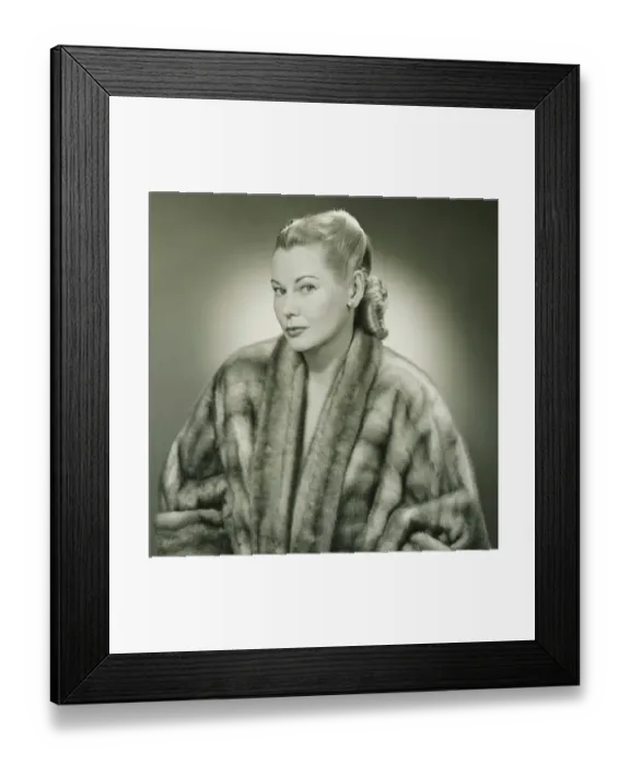 Framed Print : Young woman wearing fur coat in studio, (B&W), portrait Framed Print : Young woman wearing fur coat in studio, (B&W), portrait