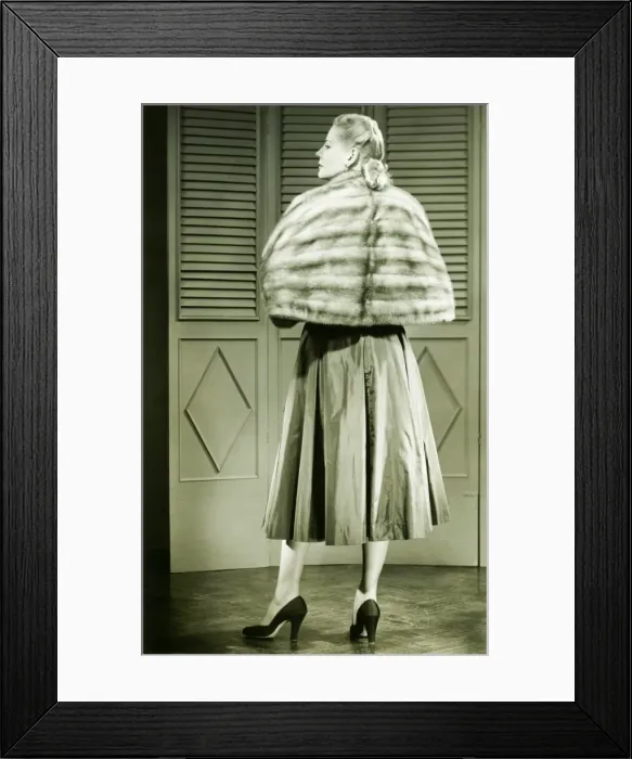 Framed Print : Young woman wearing fur standing in empty room, (B&W) Framed Print : Young woman wearing fur standing in empty room, (B&W)