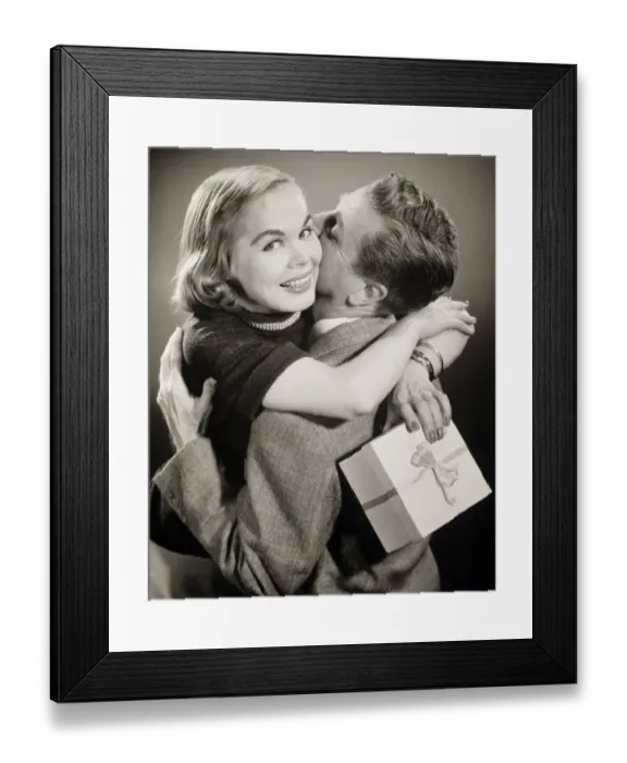 Framed Print : Couple hugging, woman holding gift, (B&W) Framed Print : Couple hugging, woman holding gift, (B&W)