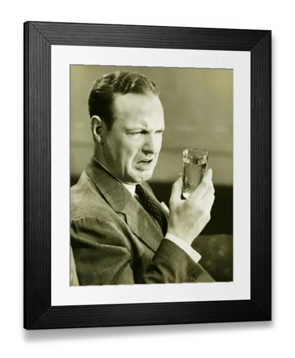 Framed Print : Disgusted man looking at glass of water, (B&W) Framed Print : Disgusted man looking at glass of water, (B&W)