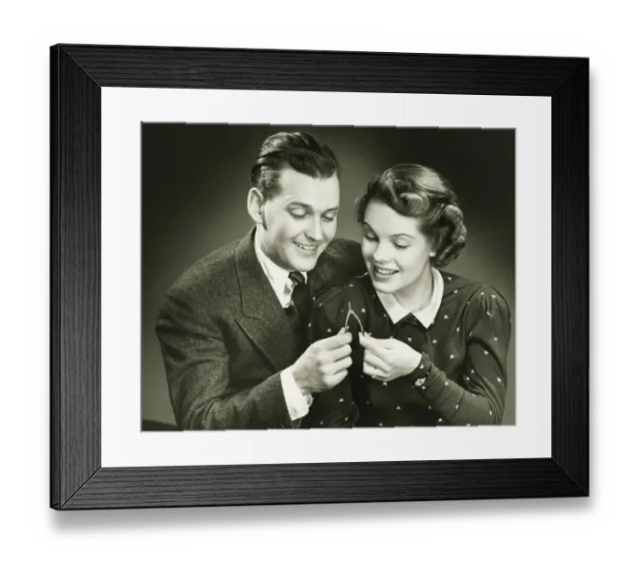 Framed Print : Couple pulling wishbone in studio, (B&W), close-up, portrait Framed Print : Couple pulling wishbone in studio, (B&W), close-up, portrait
