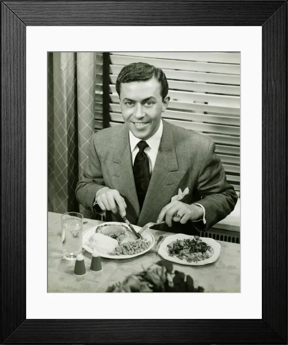 Framed Print : Young businessman eating dinner, (B&W), portrait Framed Print : Young businessman eating dinner, (B&W), portrait