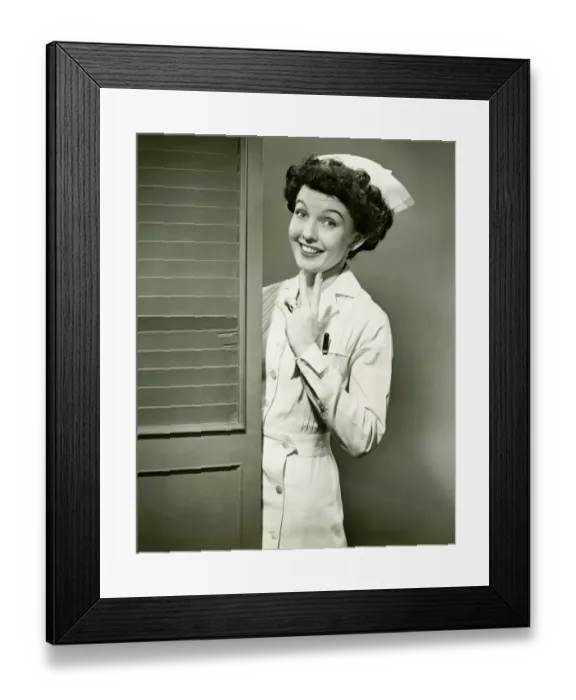 Framed Print : Young nurse smiling by open door, (B&W) Framed Print : Young nurse smiling by open door, (B&W)