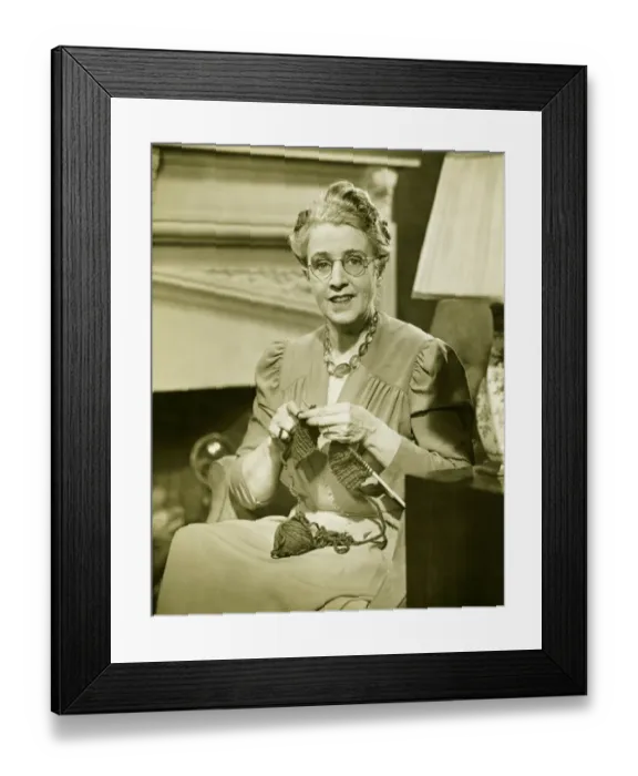Framed Print : Mature woman knitting in living room, (B&W), portrait Framed Print : Mature woman knitting in living room, (B&W), portrait