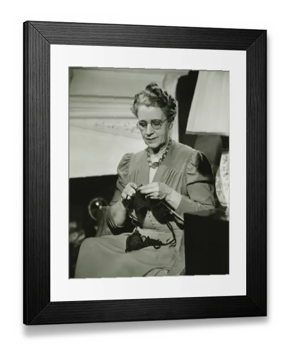 Framed Print : Mature woman knitting in living room, (B&W) Framed Print : Mature woman knitting in living room, (B&W)