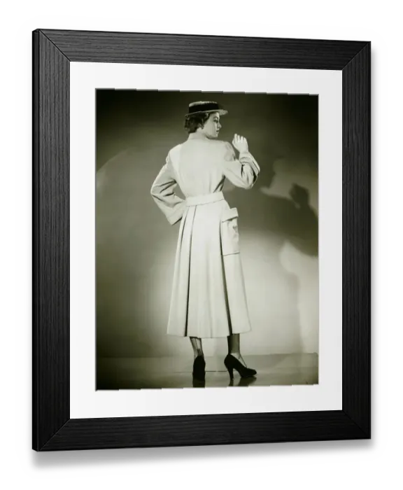 Framed Print : Woman in trench coat and hat posing in studio (Rear view), (B&W) Framed Print : Woman in trench coat and hat posing in studio (Rear view), (B&W)
