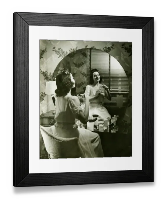 Framed Print : Young woman applying cream in front of mirror, (B&W) Framed Print : Young woman applying cream in front of mirror, (B&W)