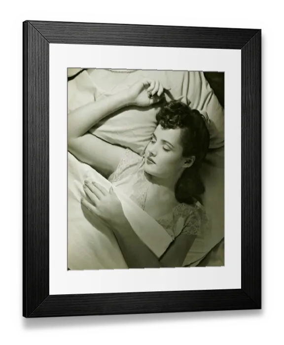 Framed Print : Young woman asleep on bed, (B&W), close-up Framed Print : Young woman asleep on bed, (B&W), close-up