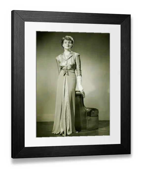 Framed Print : Woman in evening dress standing indoors, (B&W) Framed Print : Woman in evening dress standing indoors, (B&W)