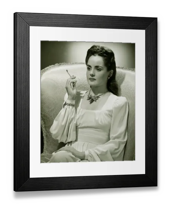 Framed Print : Young woman sitting in stylish armchair, smoking, (B&W) Framed Print : Young woman sitting in stylish armchair, smoking, (B&W)